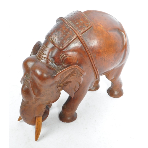 184 - An Indian inspired Oriental hand carved hardwood sculpture figure of elephant with tusks. The elepha... 