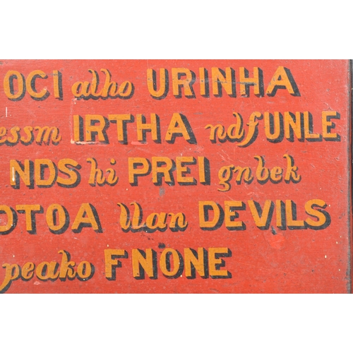 191 - A small and unusual early 20th Century hand carved and painted panel sign. In a black and red colour... 