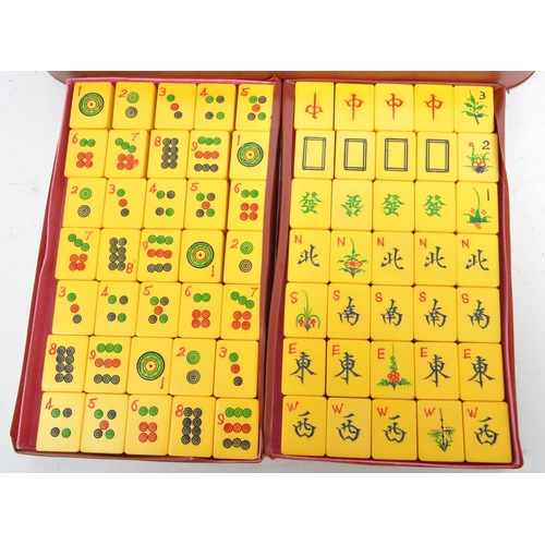 193 - A vintage 20th century Chinese Mahjong domino game set. The set featuring yellow tiles alongside a s... 