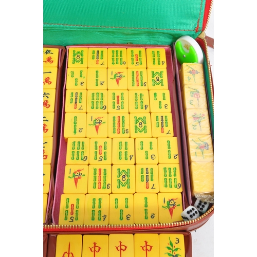 193 - A vintage 20th century Chinese Mahjong domino game set. The set featuring yellow tiles alongside a s... 