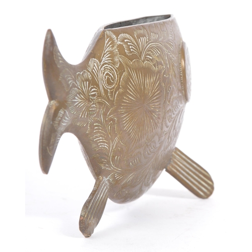 253 - An early 20th century engraved brass fish vase ornament. The fish having a rounded body, raised on f... 