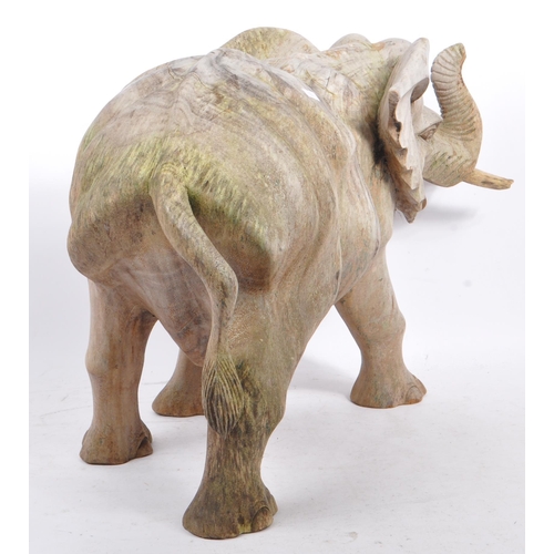 259 - A large proportioned 20th century carved wood elephant. The decoration in the form of a walking elep... 