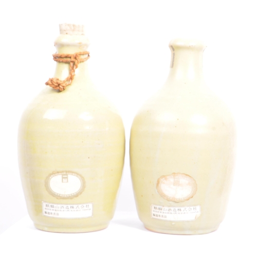 31 - A collection of vintage 20th century Japanese sake bottles and vases. Of circular form and ceramic p... 