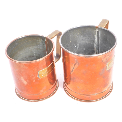 310 - A collection of 20th century copper shop measures / cups. The collection to include a series of thre... 