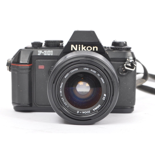 322 - Nikon - Two 20th century 35mm SLR film cameras. The lot consisting of a Nikon EM 35mm SLR camera wit... 