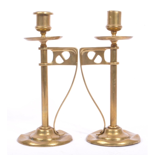 331 - A pair of early 20th century arts & crafts / Art Nouveau brass candlesticks. Having scalloped bases ... 