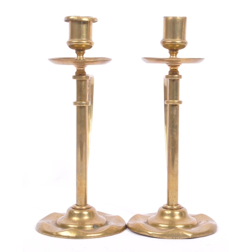 331 - A pair of early 20th century arts & crafts / Art Nouveau brass candlesticks. Having scalloped bases ... 