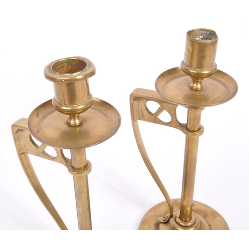 331 - A pair of early 20th century arts & crafts / Art Nouveau brass candlesticks. Having scalloped bases ... 