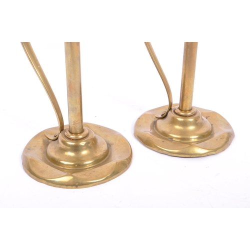 331 - A pair of early 20th century arts & crafts / Art Nouveau brass candlesticks. Having scalloped bases ... 