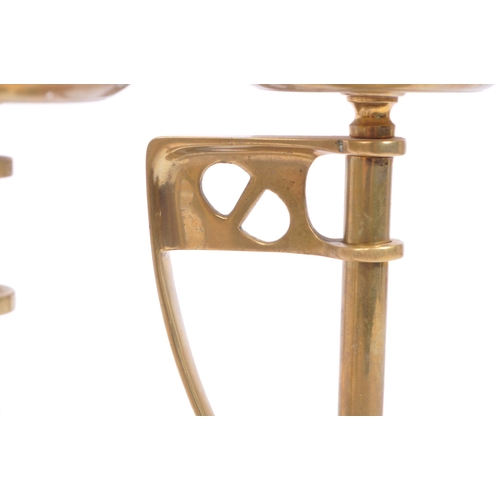 331 - A pair of early 20th century arts & crafts / Art Nouveau brass candlesticks. Having scalloped bases ... 