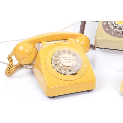 348 - A collection of three mid 20th century rotary dial telephones. The telephones each in a yellow, crea... 