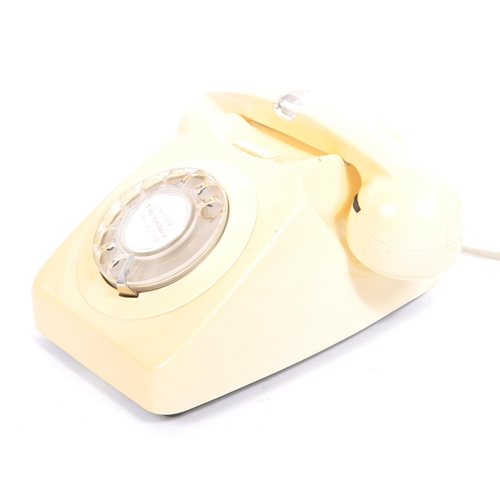 348 - A collection of three mid 20th century rotary dial telephones. The telephones each in a yellow, crea... 