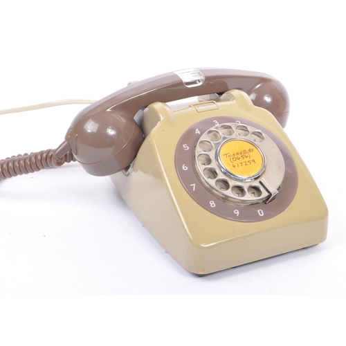 348 - A collection of three mid 20th century rotary dial telephones. The telephones each in a yellow, crea... 