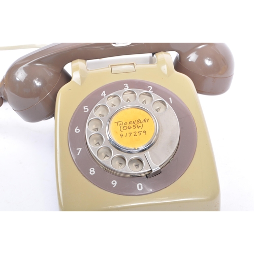 348 - A collection of three mid 20th century rotary dial telephones. The telephones each in a yellow, crea... 