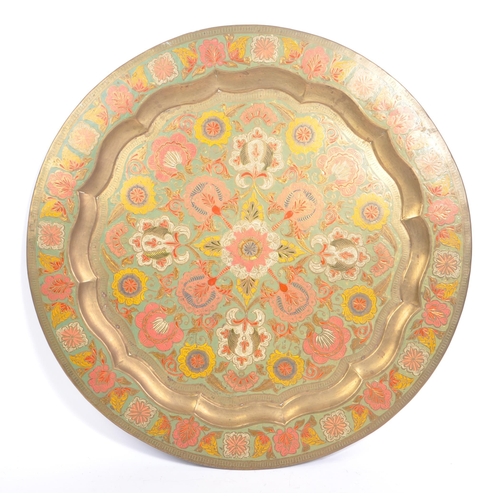 371 - A vintage 20th century Indian brass enamelled charger. Together with two pierced bowls. Having polyc... 