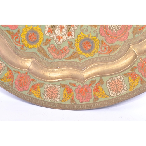 371 - A vintage 20th century Indian brass enamelled charger. Together with two pierced bowls. Having polyc... 