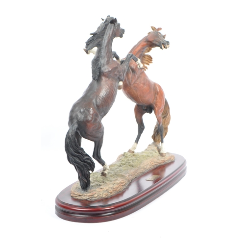 391 - A large resin figure of two rearing horses. Signed J L. Casasola. On a naturalistic base, another a ... 