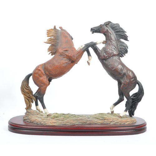 391 - A large resin figure of two rearing horses. Signed J L. Casasola. On a naturalistic base, another a ... 