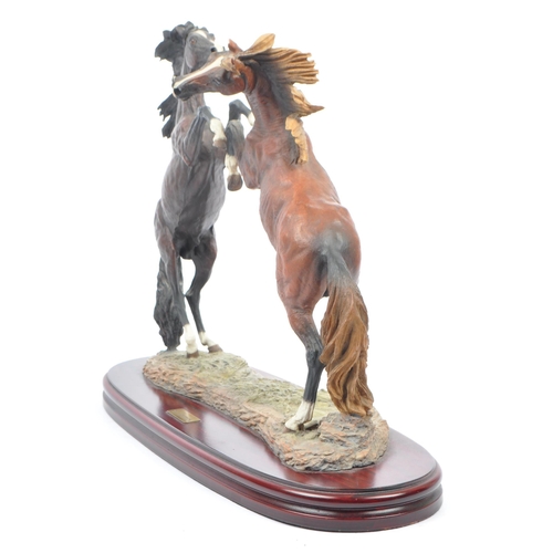 391 - A large resin figure of two rearing horses. Signed J L. Casasola. On a naturalistic base, another a ... 