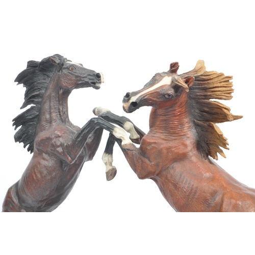 391 - A large resin figure of two rearing horses. Signed J L. Casasola. On a naturalistic base, another a ... 