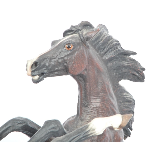 391 - A large resin figure of two rearing horses. Signed J L. Casasola. On a naturalistic base, another a ... 