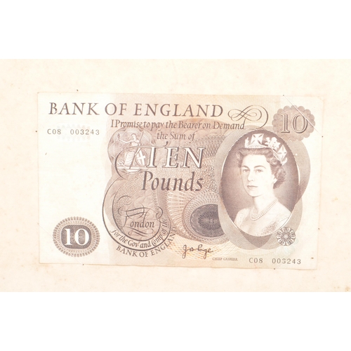 526 - A framed and glazed collection of early and mid 20th century British bank notes. The collection to i... 