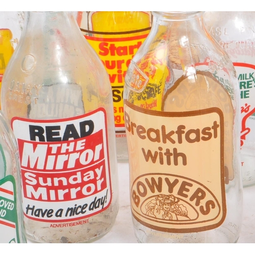 54 - A collection of 32 vintage 1980s glass 1pt / 568ml British milk bottles. Each with individual advert... 