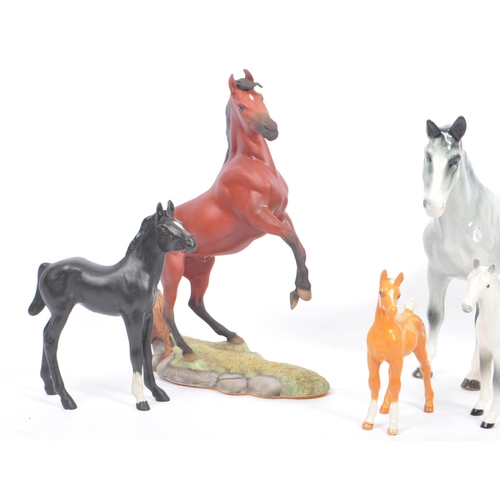 74 - Beswick - A collection of four porcelain display horse figurines. A black foal example, with palomin... 