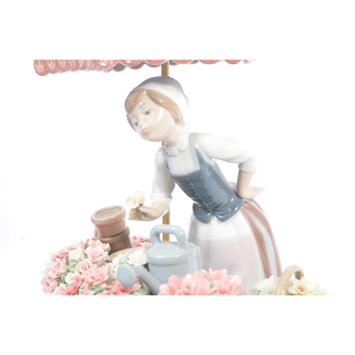 89 - Lladro - Flowers of the Season - Late 20th century porcelain china figurine. Depicting a woman with ... 