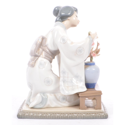 94 - Lladro - A vintage 20th century porcelain china Japanese Geisha figurine. The woman arranging flower... 