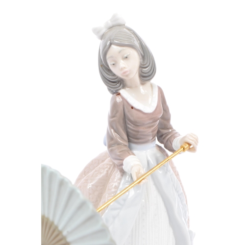 95 - Lladro - Jolie - A porcelain china female figurine. Standing position holding a parasol. Makers mark... 