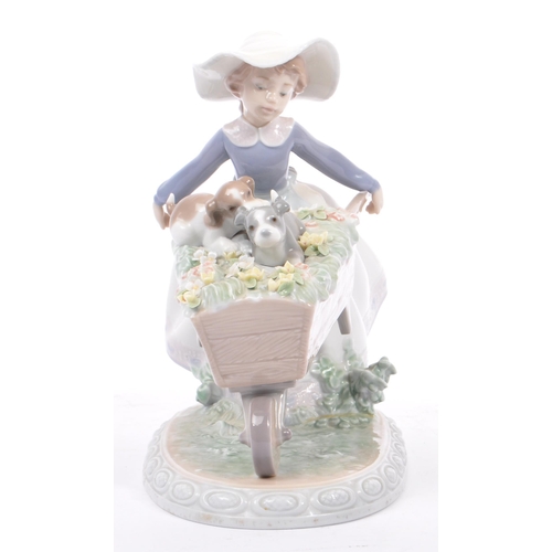 96 - Lladro - Barrow of Fun - A porcelain china tableware figurine / statue. Depicting a young female hol... 