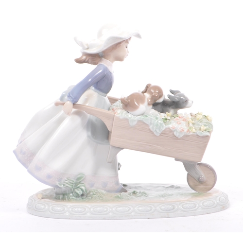 96 - Lladro - Barrow of Fun - A porcelain china tableware figurine / statue. Depicting a young female hol... 