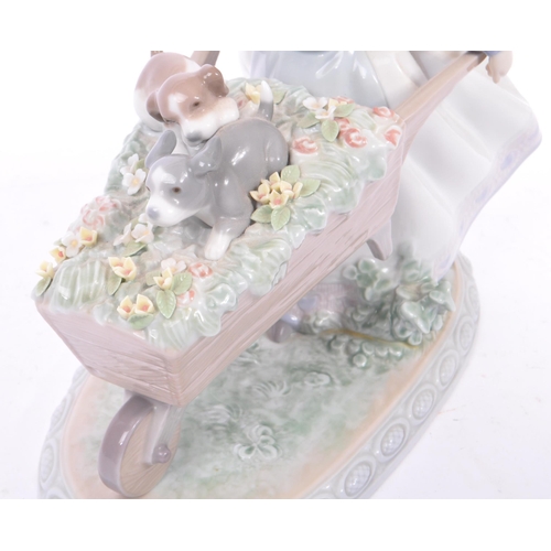 96 - Lladro - Barrow of Fun - A porcelain china tableware figurine / statue. Depicting a young female hol... 