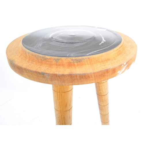 566 - A contemporary wood and resin stool / side table. The table raised on tapered legs with a turned woo... 