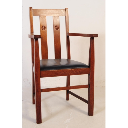 575 - An early 20th century oak Arts and Crafts carver dining chair. The chair having a drop in leather ov... 