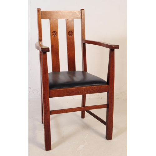 575 - An early 20th century oak Arts and Crafts carver dining chair. The chair having a drop in leather ov... 