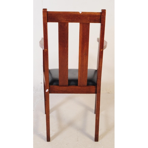 575 - An early 20th century oak Arts and Crafts carver dining chair. The chair having a drop in leather ov... 