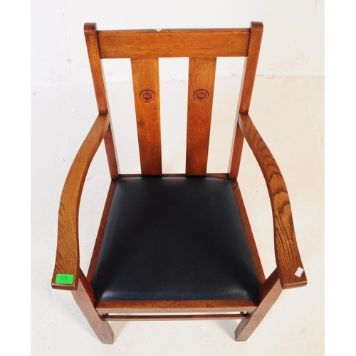 575 - An early 20th century oak Arts and Crafts carver dining chair. The chair having a drop in leather ov... 