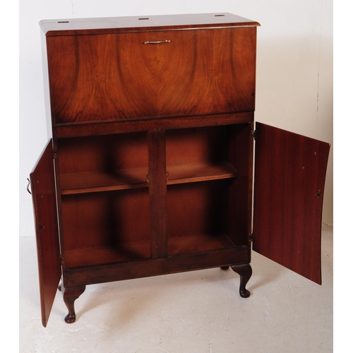 579 - A post war Art Deco walnut veneer drinks / cocktail cabinet. Rectangular form with pull down top cab... 