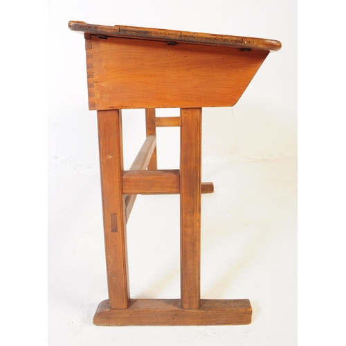 588 - A mid 20th century teak wood school writing draughtsmans desk. The desk raised on squared supports w... 