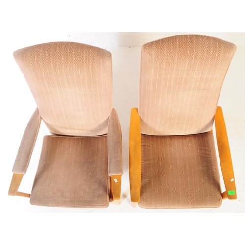 592 - Manner of Parker Knoll - a matching pair of Mid-century retro armchairs / lounge chairs raised on be... 