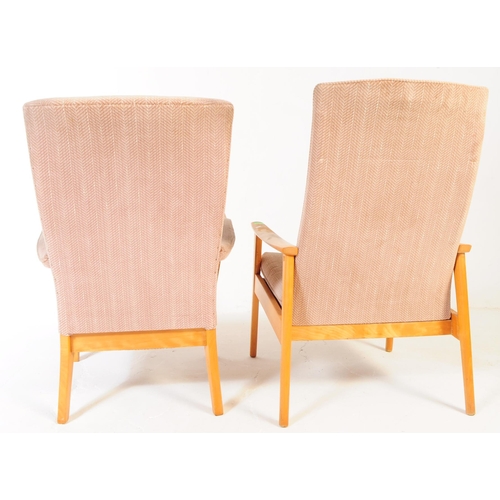 592 - Manner of Parker Knoll - a matching pair of Mid-century retro armchairs / lounge chairs raised on be... 