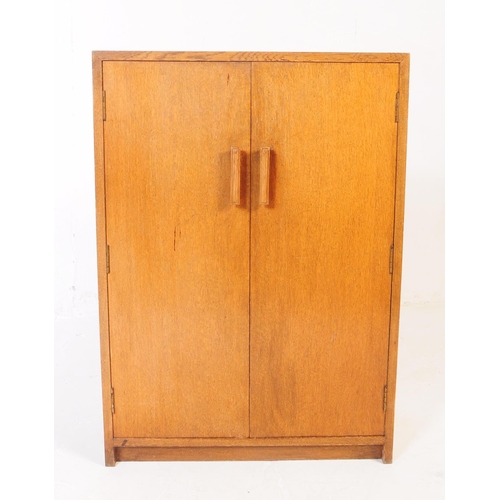 594 - An mid 20th century oak school cupboard cabinet. Raised on plinth base with twin full length panel d... 