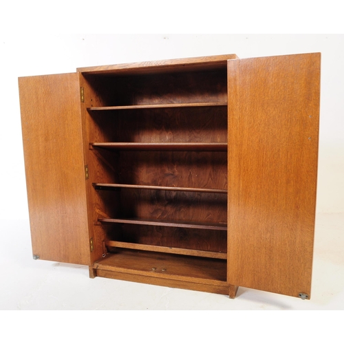 594 - An mid 20th century oak school cupboard cabinet. Raised on plinth base with twin full length panel d... 