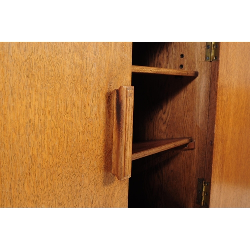 594 - An mid 20th century oak school cupboard cabinet. Raised on plinth base with twin full length panel d... 