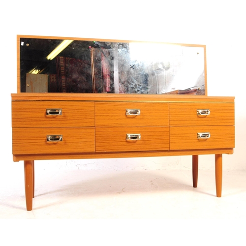 619 - A retro 20th Century melamine teak wood effect dressing table chest. Having a single mirror back abo... 