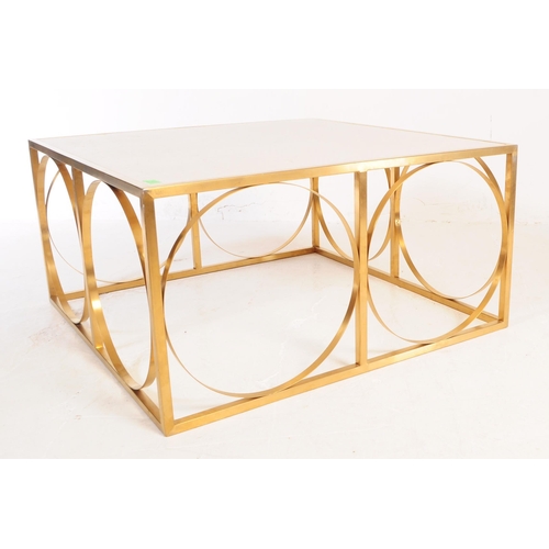 620 - A contemporary stainless steel low coffee table. The table having a resin top raised on gold stainle... 