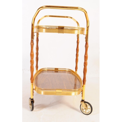 622 - A mid 20th century circa 1970s gilt frame cocktail / drinks trolley. The trolley having two tiers wi... 