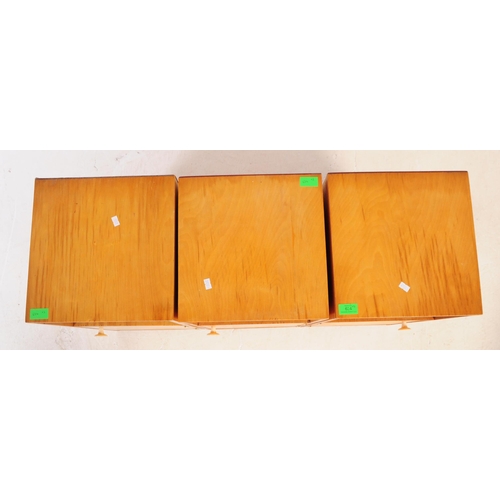 634 - A collection of three mid 20th century plywood bedside table / cupboards. The bedsides each featurin... 